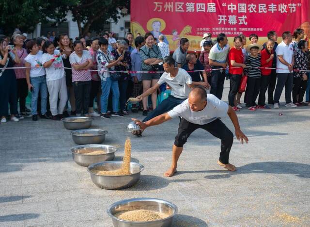 庆丰收，万州区通过丰富多彩的群众性庆祝活动充分展现广大农民群众的时代风采。图为正在举行的抢运粮食比赛。冉孟军摄