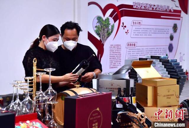 图为9月21日，台农二代陈正信和妻子叶丽清在公司整理展示销售的产品。张斌摄