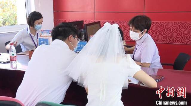 资料图：穿着婚纱登记结婚的新人。杨季峰摄