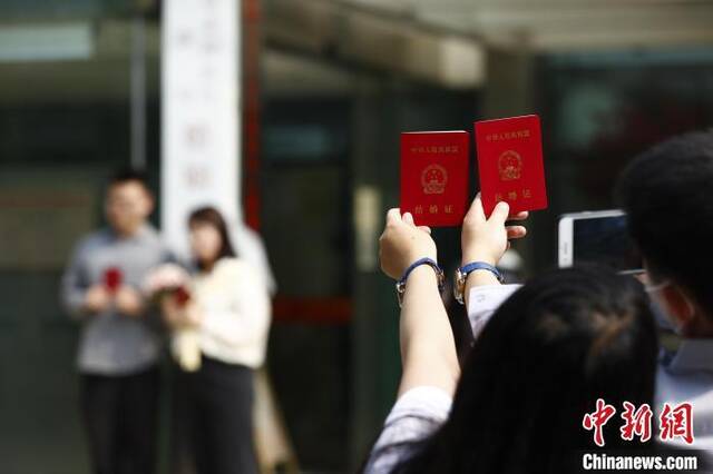 资料图：5月20日上午，北京市海淀区婚姻登记处外领证自拍的新人。富田摄