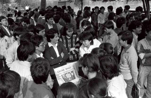 1989年，海口市东湖英语角，英语爱好者们通过《中国日报》来学习英语。/视觉中国