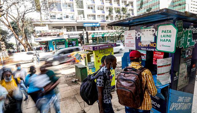 人们在肯尼亚首都内罗毕市中心一处M-Pesa代理网点办理业务。新华社记者张宇摄