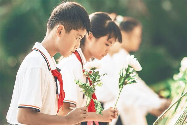 少先队员为烈士献花，表情肃穆。海南日报记者 封烁 摄