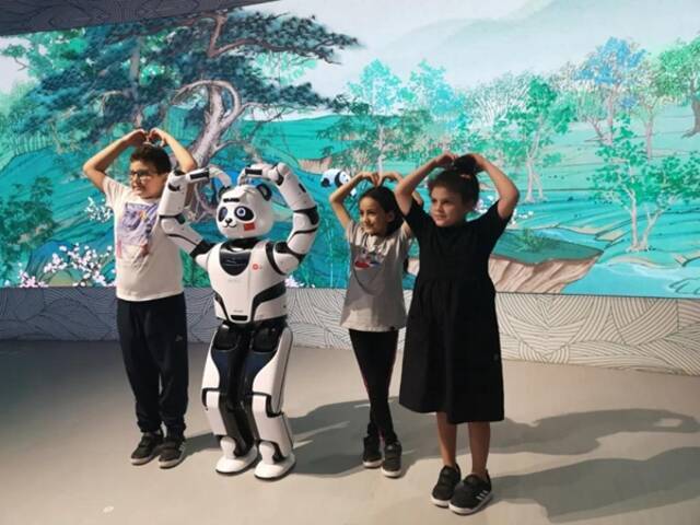 图为10月1日参观者在迪拜世博会中国馆与熊猫机器人合影。新华社记者闫婧摄
