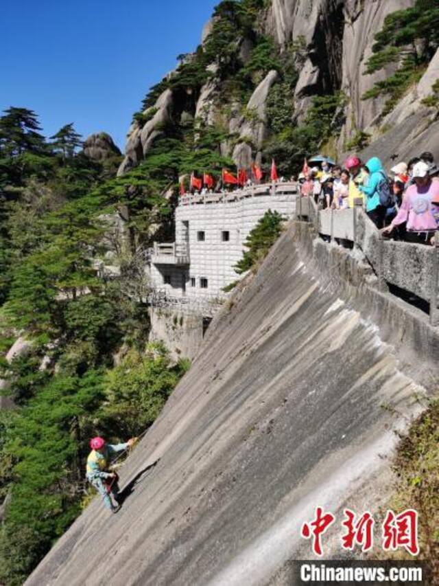 李培生戴好安全绳，从峭壁顺绳而下。葛旭芳摄