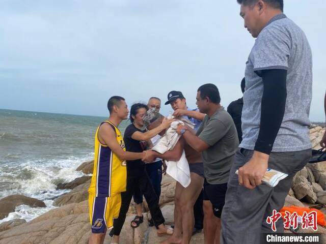 获救群众向民警高鑫（左一身穿黄色篮球服）表示感谢。海南海岸警察供图