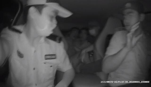 坐在后座的嫌疑人李某踢踹正在开车的民警（视频截图）