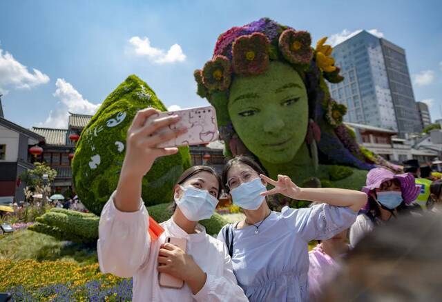 游客在昆明市金碧广场立体花坛前自拍陈欣波摄