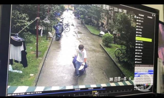 ▲网传视频中，一男子拉着行李箱离开案发小区。图片来源/视频截图