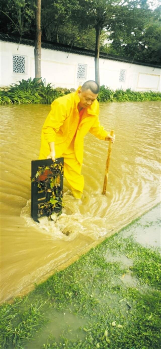 脚“摸”下水井 抢排积水点