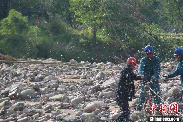 山西祁县来远镇谷峪口村，供电队员在准备渡河工作。高岩摄
