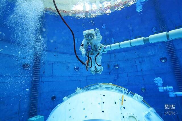 航天员翟志刚水下训练时在机械臂上移动（8月25日摄）。新华社发（孔方舟摄）