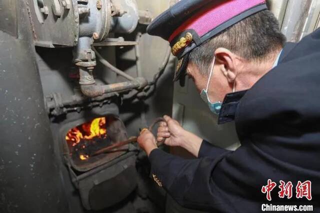 资料图：10月，哈尔滨铁路陆续启动站车供暖工作，图为列车员检查锅炉。哈铁提供