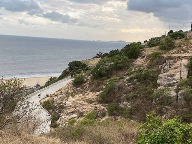 平海镇多个村子在山与海之间，海边也有执勤人员正在巡逻。