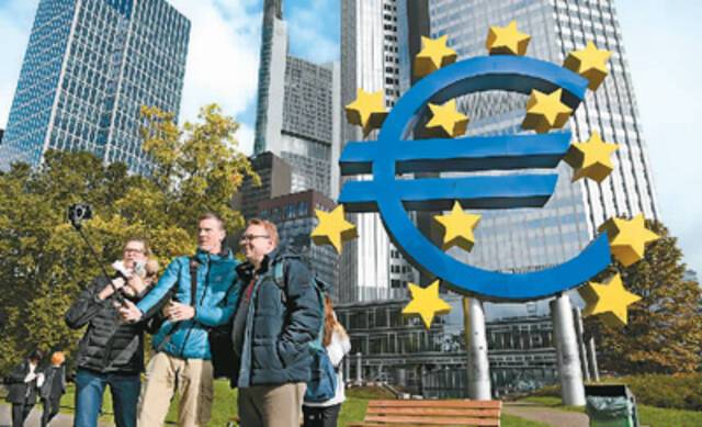 十月十三日，人们在位于德国法兰克福欧元雕塑前自拍留影。新华社记者逯阳摄