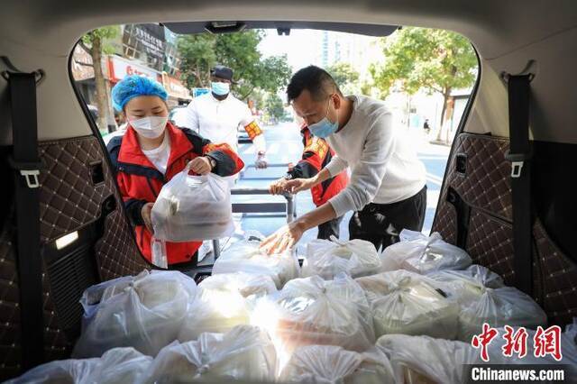 10月24日，黔菜馆工作人员和志愿者将午餐转运上车。瞿宏伦摄