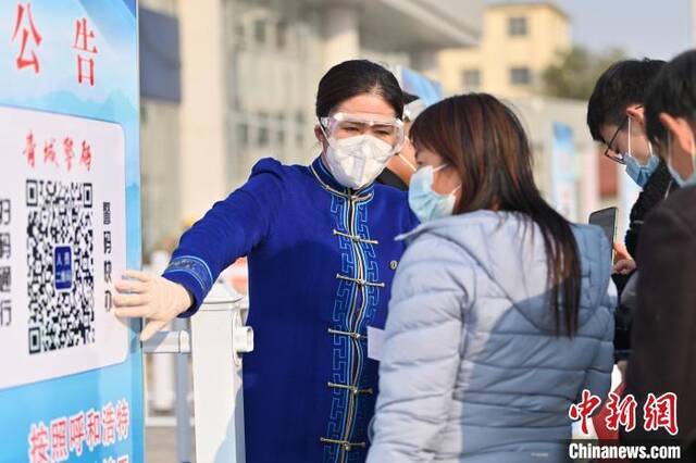10月24日，呼和浩特火车站，工作人员引导旅客出示健康信息。刘文华摄