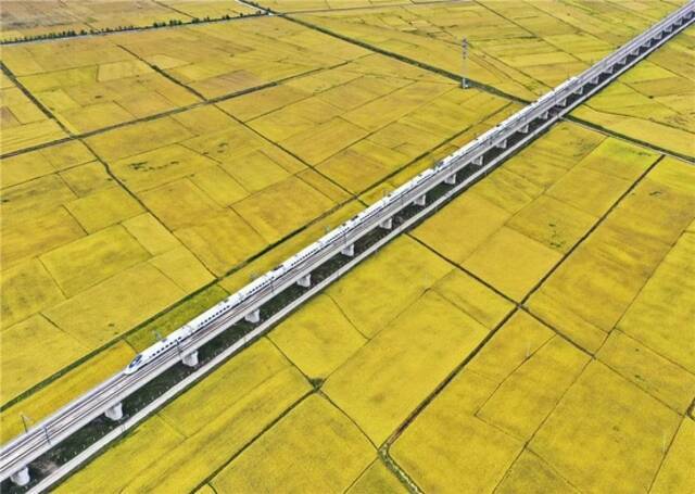  9月19日，高铁列车从吉林省公主岭市沃野间驶过（无人机照片）。新华社记者张楠摄