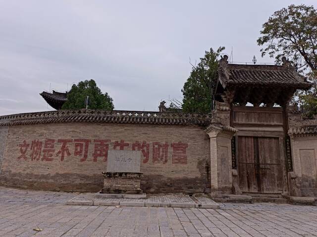 光村国保文物福胜寺的围墙上写着：文物是不可再生的财富。新京报记者吴采倩摄