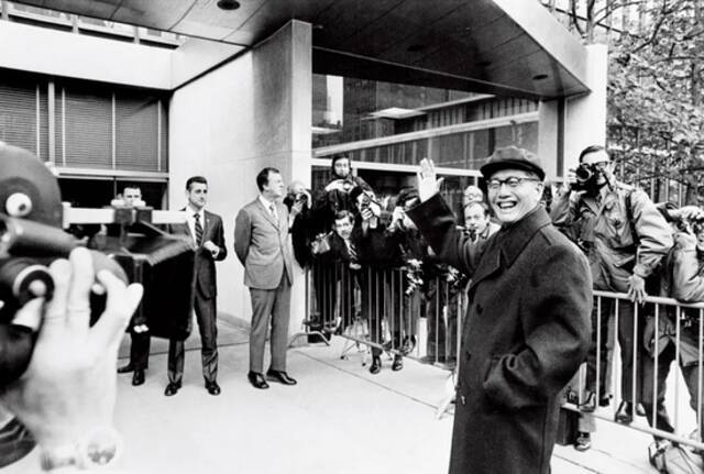  1971年11月12日，美国纽约，中国代表团团长、外交部副部长乔冠华在联合国总部向记者们挥手致意。图/人民视觉