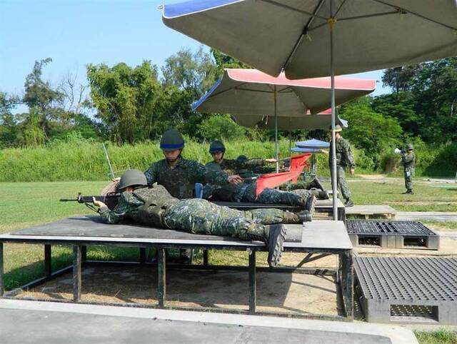 台军士兵靶场训练时垫软垫、打遮阳伞台媒资料图