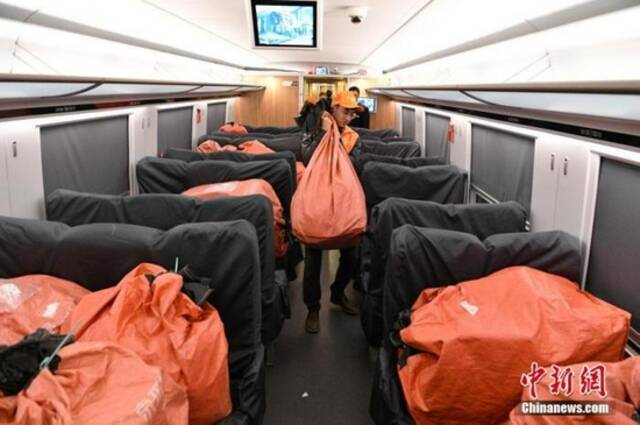 资料图：2019年11月11日，工作人员将成都发往南京的包裹装上列车。中新社记者刘忠俊摄