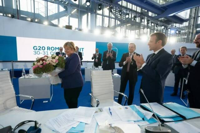 当地时间2021年10月31日，意大利罗马，G20领导人第十六次峰会举行，默克尔手捧鲜花。图/IC photo
