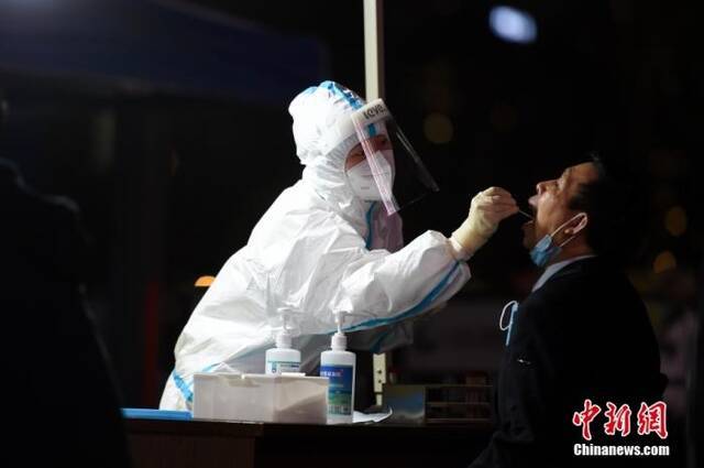 医护人员为居民做核酸检测。中新社记者何蓬磊摄