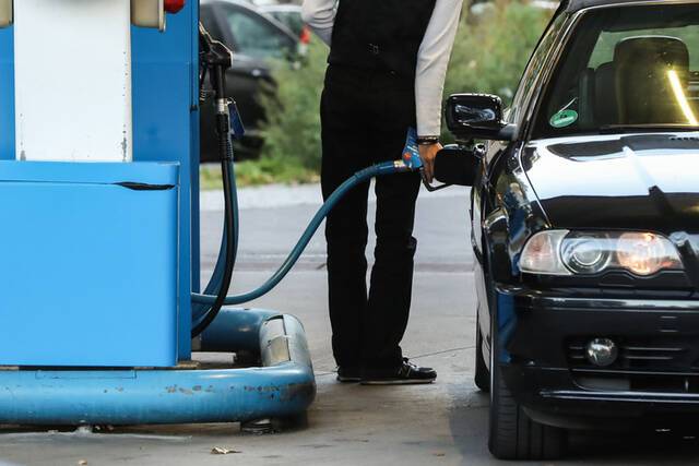 10月1日，一名顾客在德国柏林的一家加油站为汽车加油。新华社记者单宇琦摄