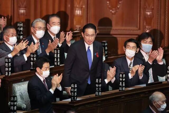 ▲10月4日，在日本国会众议院举行的首相指名选举中，自民党新总裁岸田文雄（中）起身致谢。图/新华社