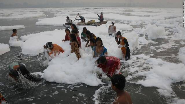 有信徒在被有毒泡沫覆盖的河水中沐浴。（图源：CNN）