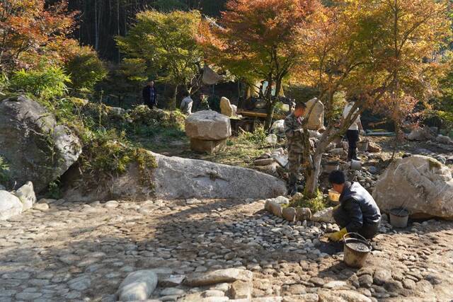 图为蓝山县湘江源瑶族乡坪源村，当地村民在铺设游步道。（胡盼盼摄）