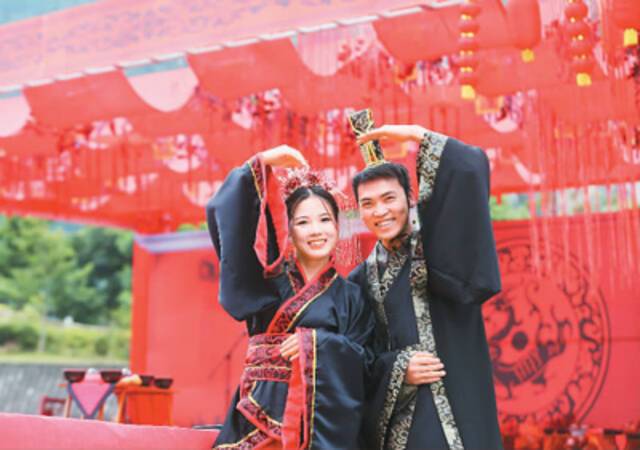 在今年六月举行的鲁渝青年婚恋交友活动中，一对新人在重庆市黔江区城市大峡谷景区合影。杨敏摄（人民视觉）