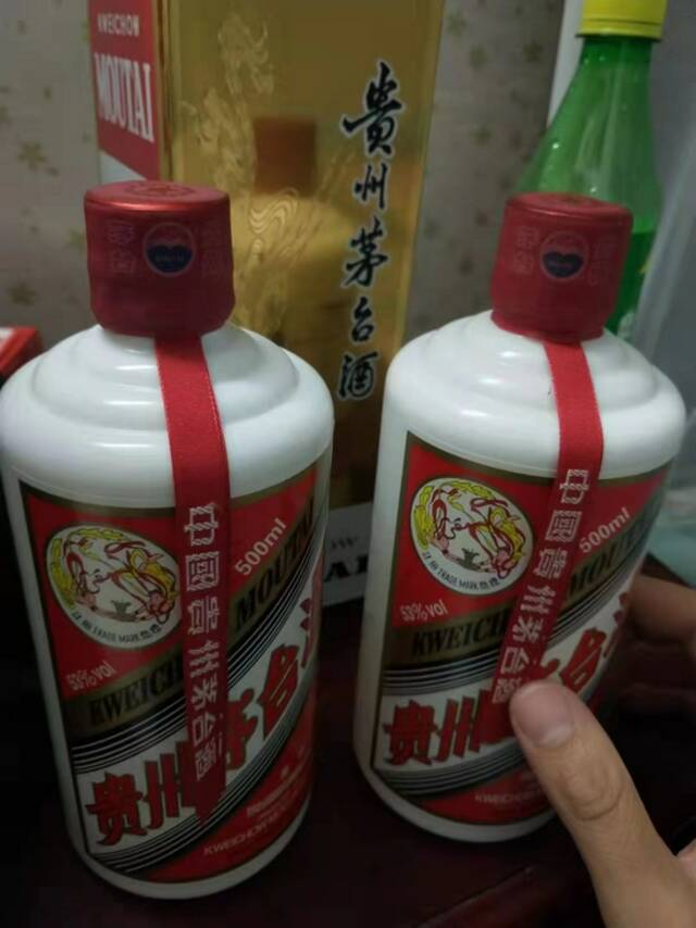 孙阳向记者展示的飞天茅台酒样品照片，其称左为正品，右为高仿品。