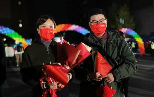 ↑田女士和儿子带着花，在门口等待母亲