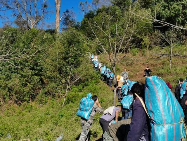  11月20日，当地采用背物资上山的方式进行后勤保障。图片来自镇沅县委宣传部