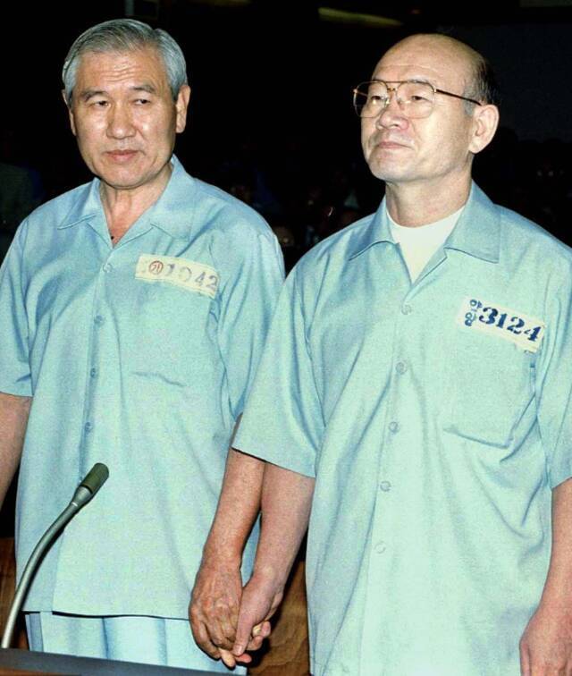 1996年，全斗焕和卢泰愚手拉手受审。