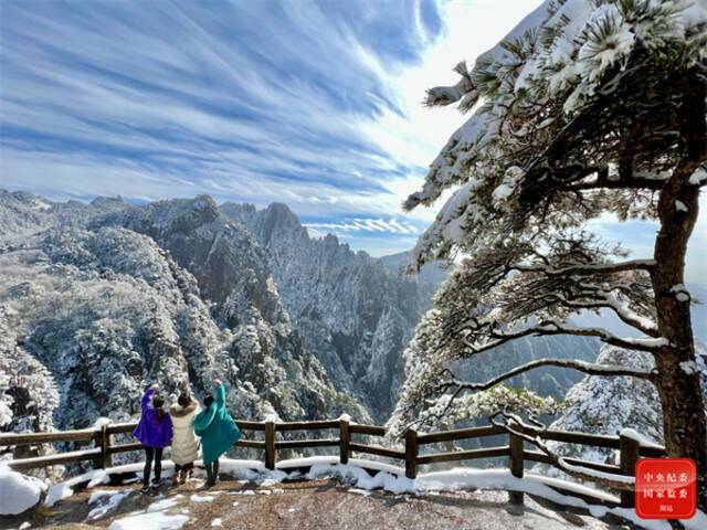 黄山迎来今年冬季的初雪，山峦树木披上银装，宛如童话般世界，游客们纷纷打卡留念，用相机定格住这美好画面。(安徽省黄山市屯溪区纪委监委供程剑  摄)