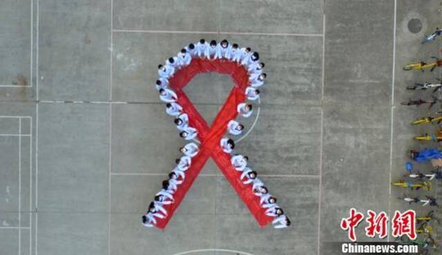 资料图：大学生们携手“抗艾”，拼大型“红丝带”图案。孟德龙摄