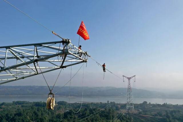 作业人员在白鹤滩-江苏特高压线路跨越长江铁塔上施工图：央视网