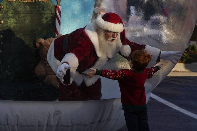 去年，商场里的圣诞老人只能隔着气球与孩子们拥抱图源：彭博社