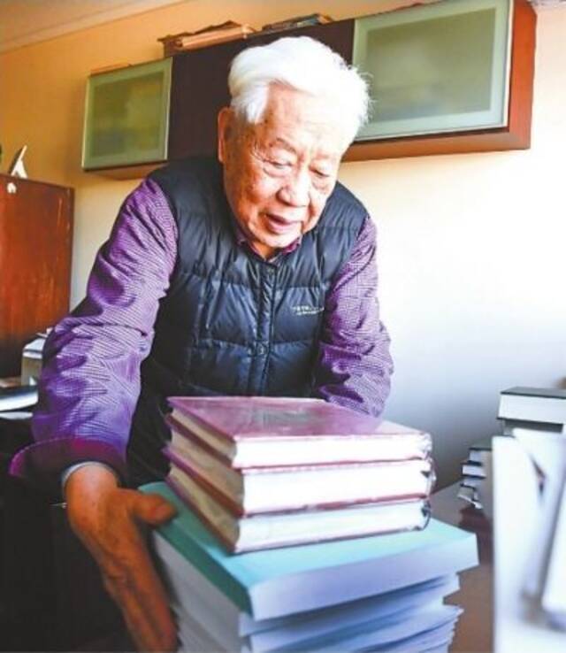 中南财经政法大学退休教授赵德馨在家中书房办公，清理案头书籍和资料。记者高勇摄