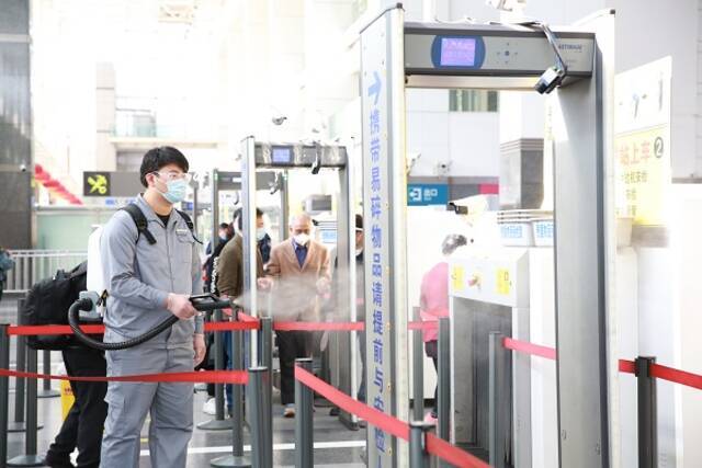 图说：工作人员在上海站消毒安检设备