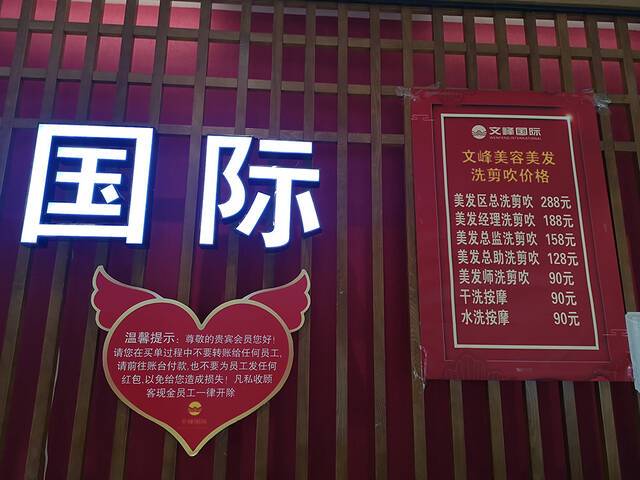 肇嘉浜路店内，收银台背后的墙上贴有洗剪吹价格表。澎湃新闻记者陈少颖图