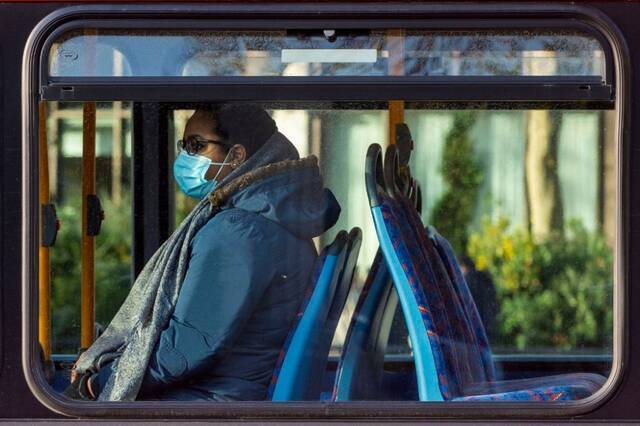 12月9日，戴口罩的乘客在英国伦敦乘坐公交车。（新华社发，史蒂芬·程摄）