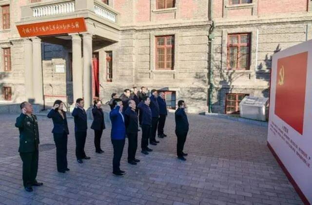在北大红楼南侧广场，东城区委常委班子成员在区委书记孙新军的带领下面向党旗，共同重温入党誓词。图/“北京东城”公众号