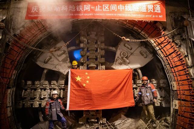 ↑在俄罗斯首都莫斯科，工作人员在地铁项目隧道全部贯通后在盾构机前合影（2019年12月26日摄）。新华社记者白雪骐摄