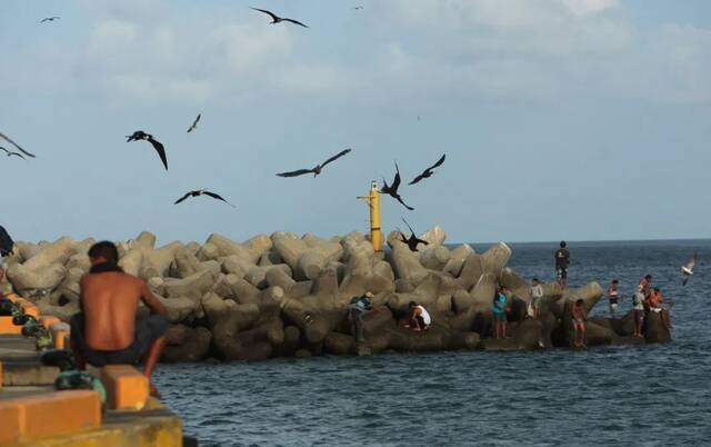 2010年4月9日，尼加拉瓜南圣胡安湾，游人在海边玩耍。（新华社发）