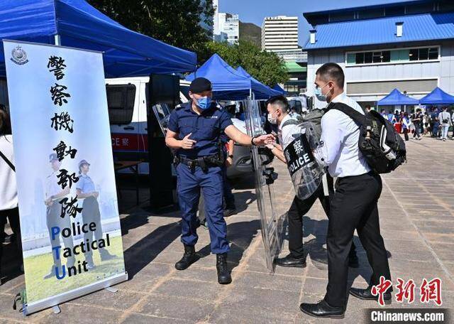 香港警队12月12日在香港警察学院举办“警察招募·体验日”。图为警察机动部队队员向参加者介绍其工作。政府新闻网供图