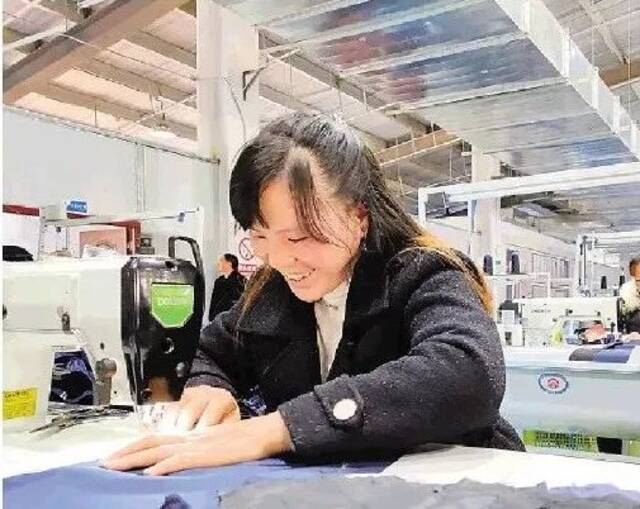 1月2日，一名搬迁群众在靖安新区一个服装厂工作。图源：新华每日电讯